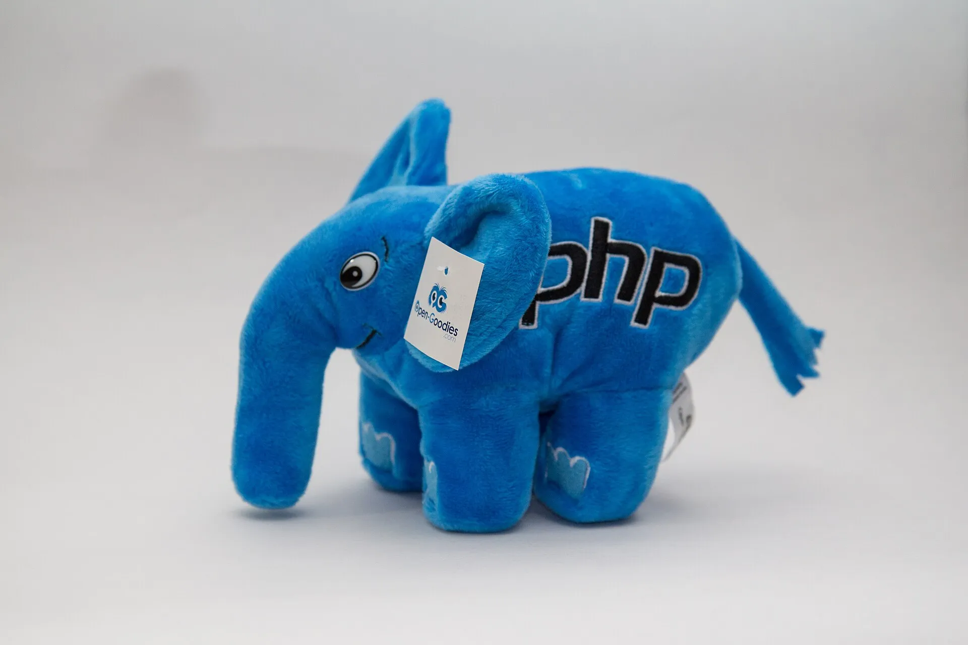 A blue plush elephant toy with php stitched on its side